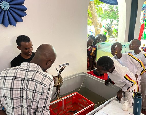 Students observing a mud crab and tank of Milkfish species.